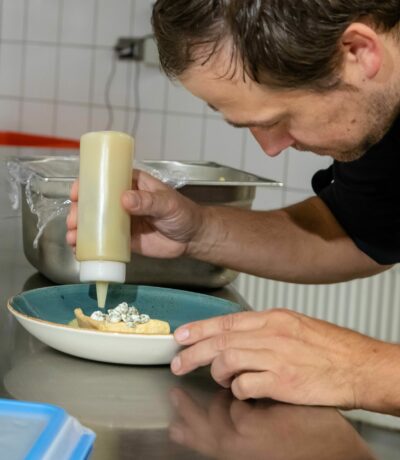 Küchenchef Benjamin Kettmann richtet das Kürbis-Eis auf dem Teller an.